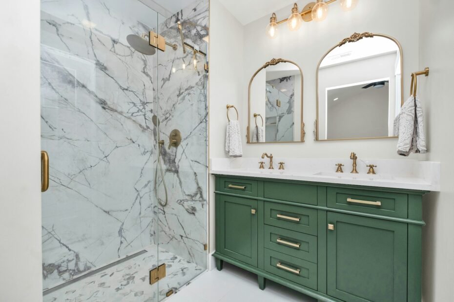 Remodeled bathroom with green vanity cabinets and a marble-tiled walk-in shower