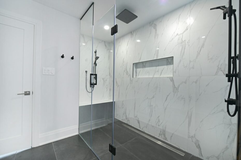 Modern tiled walk-in shower with a frameless glass panel and low-threshold entry