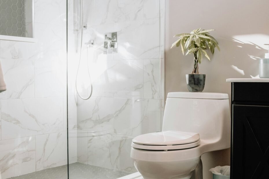 Bathroom with a glass shower enclosure, marble tile walls, and a white toilet