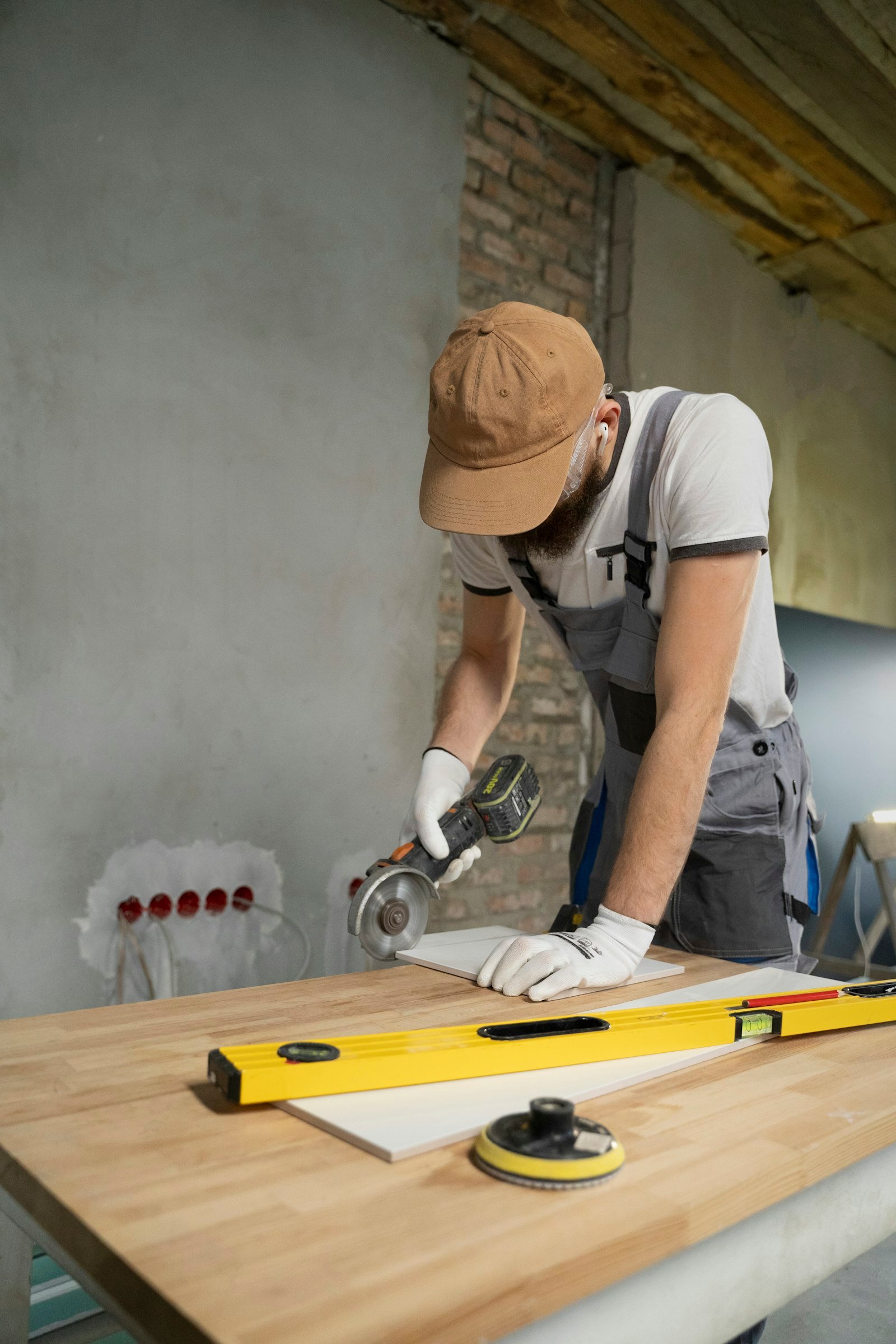 Contractor cutting tile with an angle grinder during an off-season bathroom remodel
